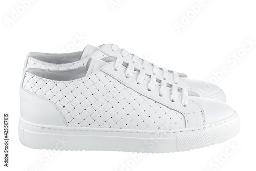 Pair of athletic shoes made of strips of braided white leather, with laces and a white rubber sole, isolated on a white background. Side view.