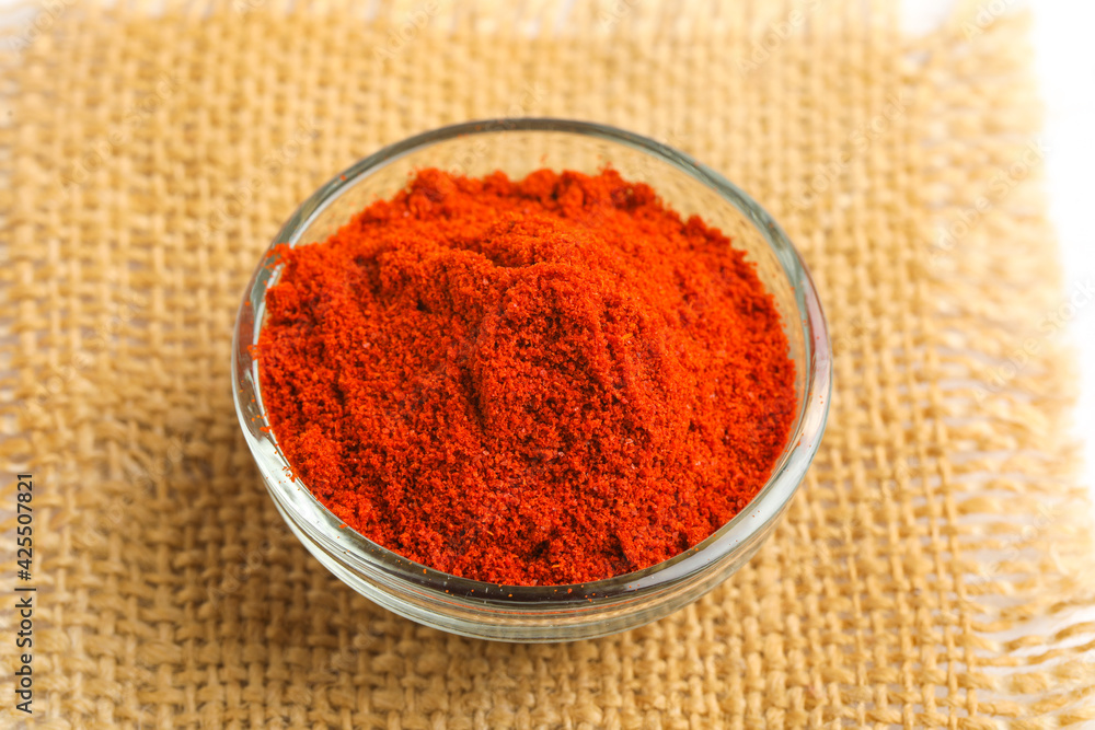 Red chilli powder in glass bowl on white background. Red chilli powder in glass bowl on white background.