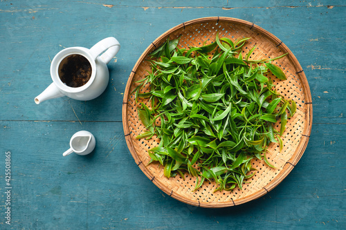 Tableau sur toile Green tea leaves in a wooden tray