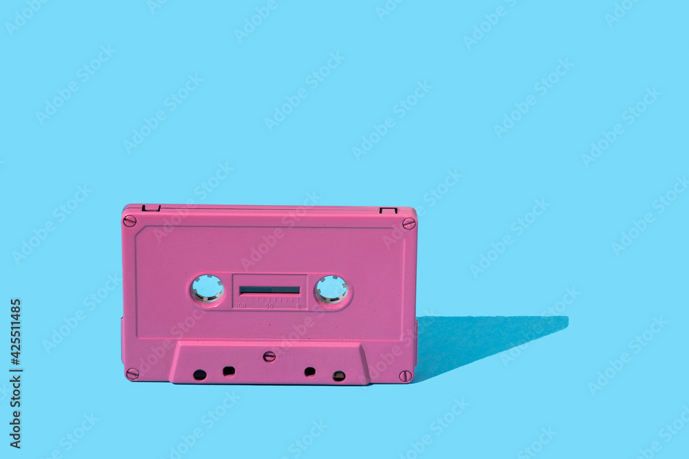 Obraz premium pink audio cassette on a blue background. stock photo