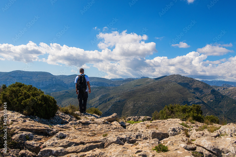 Hikers walking on mountains, in a sunny spring day. In La vall de laguar, Alicante (Spain)