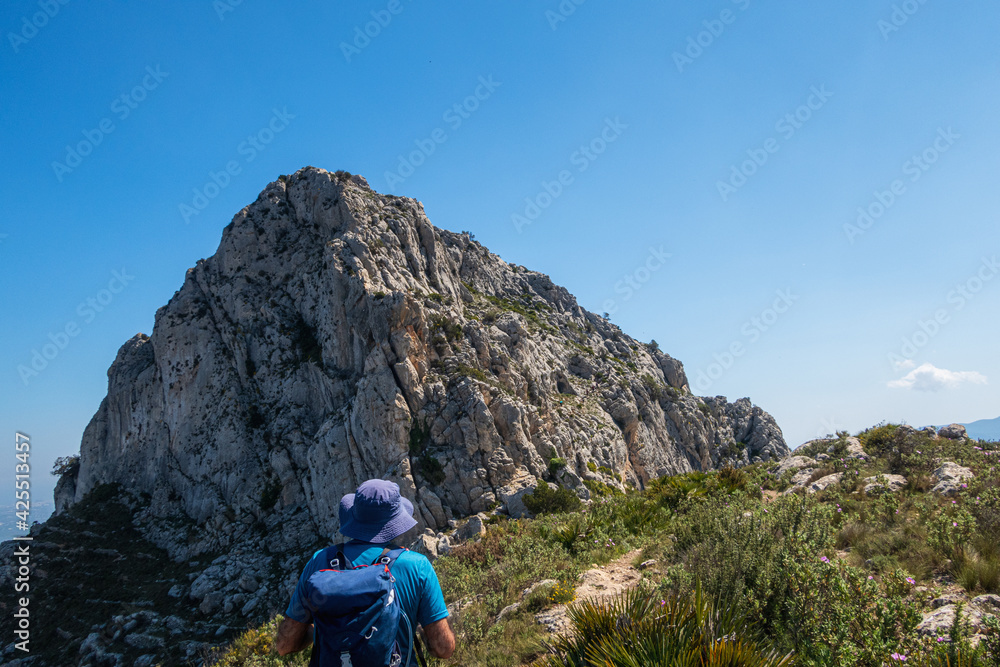 Fototapeta premium Hikers walking on mountains, in a sunny spring day. In La vall de laguar, Alicante (Spain)
