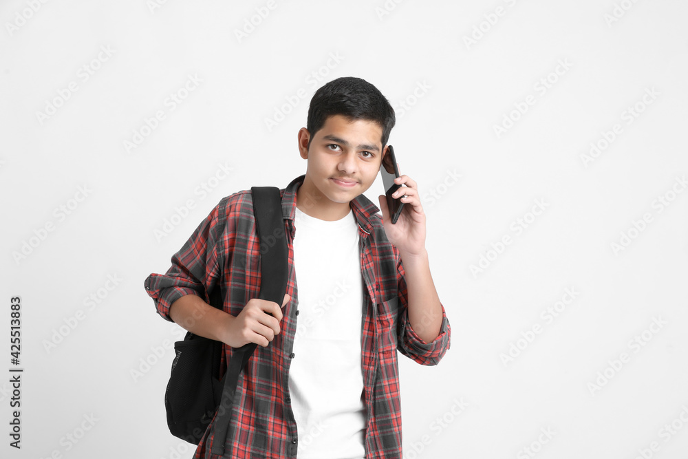 Indian college student talking on smartphone on white background. Indian college student talking on smartphone on white background.