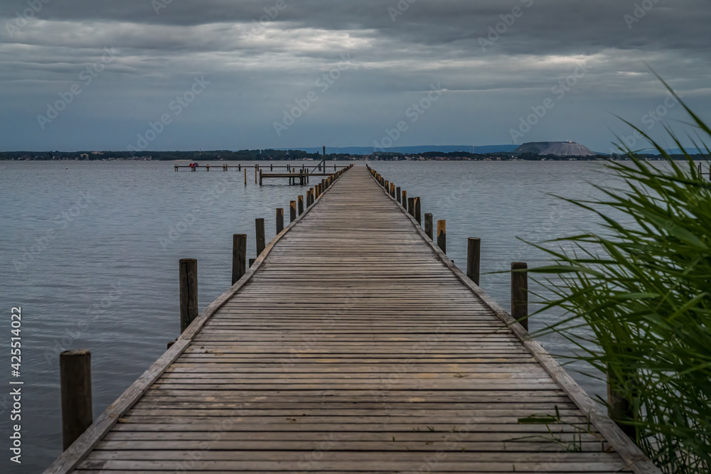 A jetty at the Steinhuder Meer with the Marina and the spoil heap of the potash mine in the background, seen in Mardorf, Lower Saxony, Germany