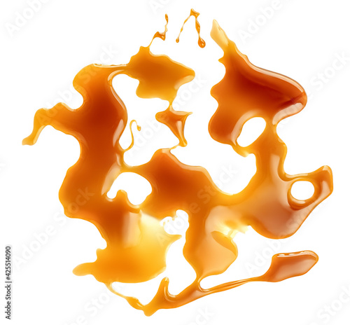 Flowing  Caramel sauce isolated on a white background close up.  Melted  caramel spots. Top view photo