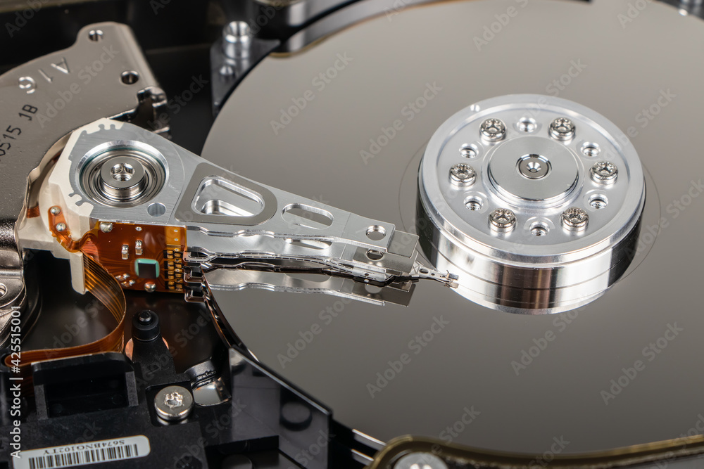 Disassembled hard drive from the computer, hdd with mirror effect. Opened hard drive from the computer hdd with mirror effects. Part of computer pc, laptop. Disassembled hard drive from the computer, hdd with mirror effect. Opened hard drive from the computer hdd with mirror effects. Part of computer pc, laptop.