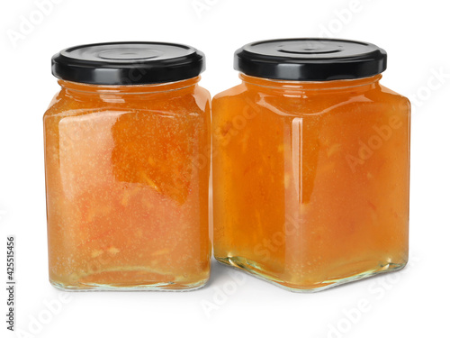 Delicious orange marmalade in jars on white background