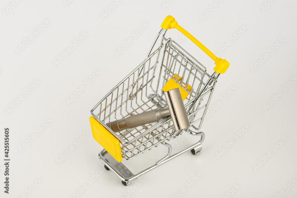 metallic safety razors in shopping cart isolated on white background 