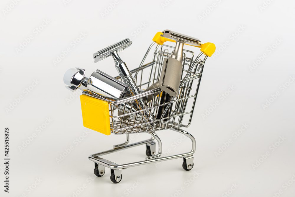 metallic safety razors in shopping cart isolated on white background 