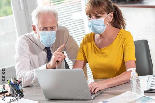 Businesspeople wearing protective medical mask in office during coronavirus outbreak