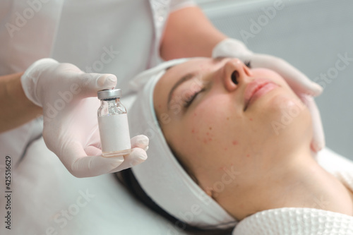 A young woman in a cosmetology clinic, undergoing acne treatment with injections. An effective remedy for acne