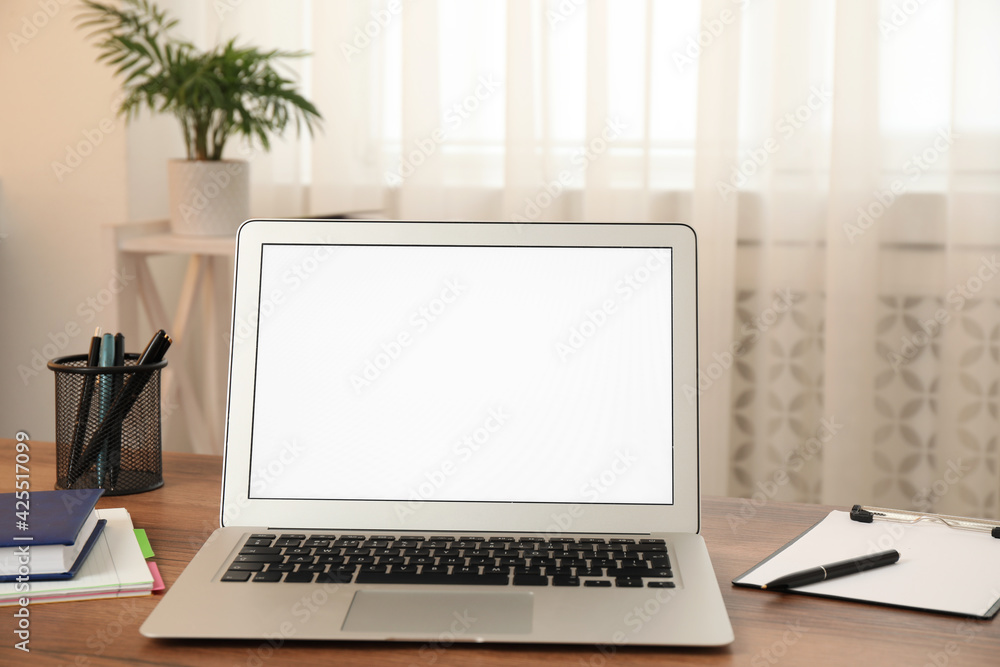 Modern laptop with blank screen on table at home Modern laptop with blank screen on table at home