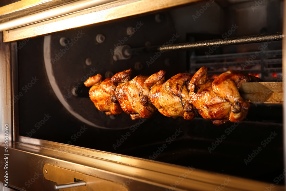 Grilling whole chickens in rotisserie machine, closeup Grilling whole chickens in rotisserie machine, closeup