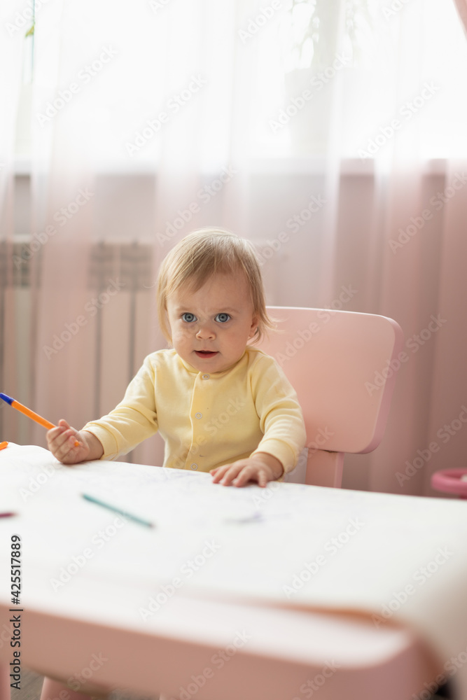 Baby draws at the table Baby draws at the table