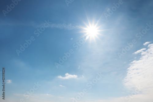 Sun and white clouds in blue sky outdoors