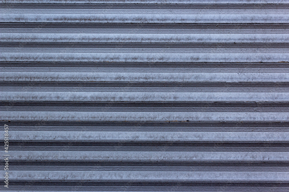 Obraz premium Corrugated sheet metal, badly painted with gray paint for background. Metal corrugated roofing sheet.Painting of metal surfaces for rust control Abstract background for sites and layouts. Iron fence