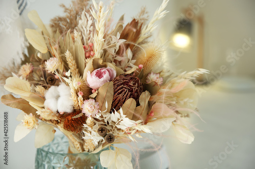 Bouquet of dry flowers and leaves on blurred background