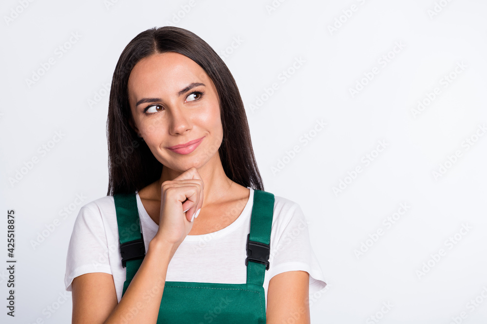 Photo of minded smart lady finger chin look empty space wear green overall isolated white color background Photo of minded smart lady finger chin look empty space wear green overall isolated white color background