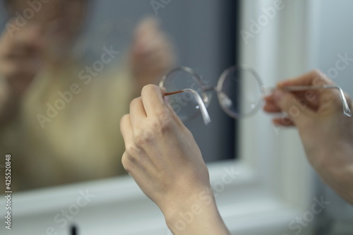Hands of woman holding eyeglasses