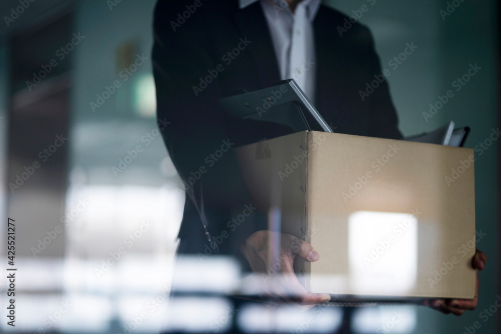 Fired businessman carrying box of personal items Fired businessman carrying box of personal items