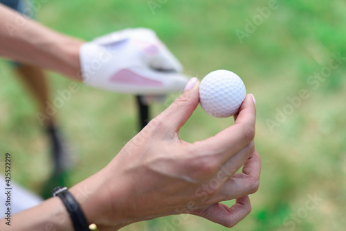 Closeup of golf balls in female hands