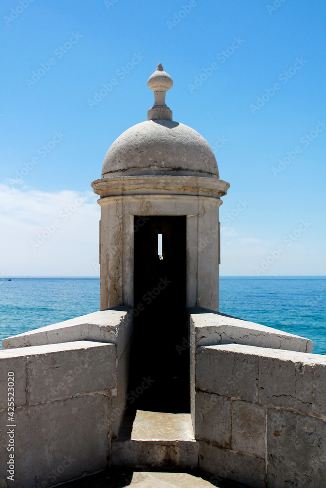 Watchtower of the fortress on the beach in Sesimbra village Watchtower of the fortress on the beach in Sesimbra village