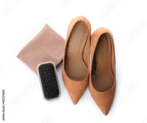 Stylish footwear and brush on white background, top view. Shoe care accessory © New Africa