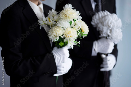 Mourning man and woman with flowers at funeral 