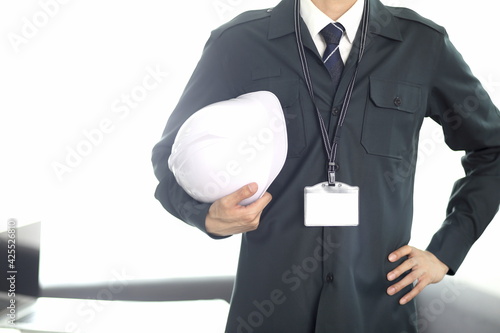 Engineer standing with hardhat in office 