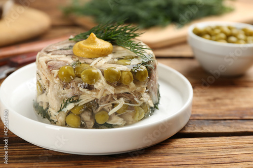 Delicious aspic with meat on wooden table, closeup photo