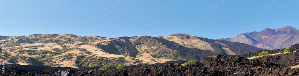 Mount Etna in Sicily, Tallest active Europe volcano in Italy. Panoramic wide view of the active volcano Etna, volcanic ash and lava fields, traces of volcanic activity.