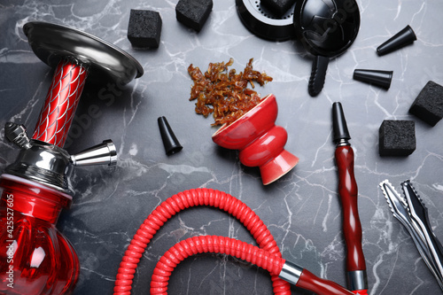 Flat lay composition with parts of hookah on black marble table