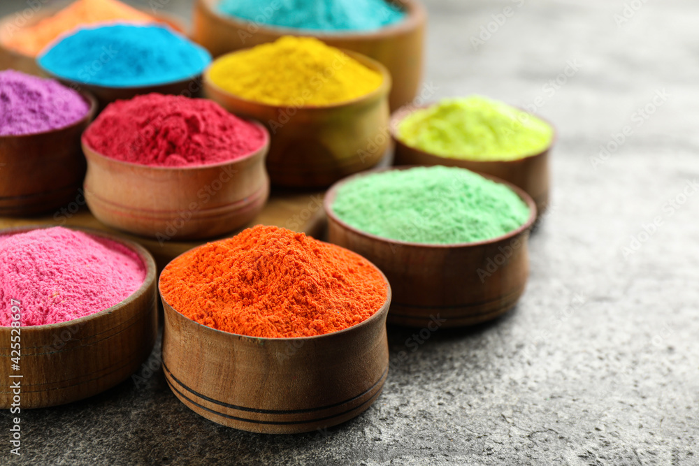 Colorful powder dyes on grey background, closeup. Holi festival Colorful powder dyes on grey background, closeup. Holi festival