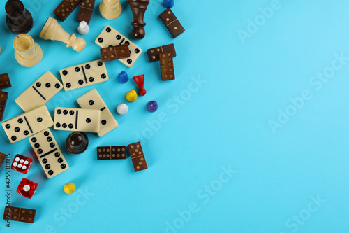 Canvas Print Components of board games on light blue background, flat lay