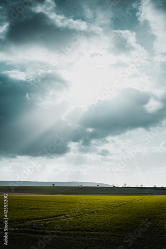 Beautiful natural panorama countryside with dramatic weather and light rays and spring fields and meadows and wild spring weather. Lower Saxony  Germany