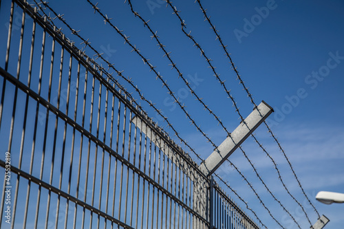 barbed wire fence too keep out burglars from home and keep in prisoners in imprisonment
