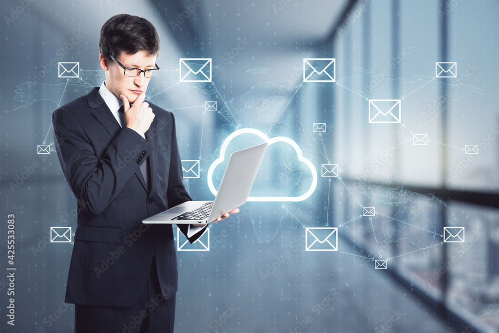 Cloud and email service concept with businessman with laptop and digital screen with cloud icon and envelope symbols Cloud and email service concept with businessman with laptop and digital screen with cloud icon and envelope symbols