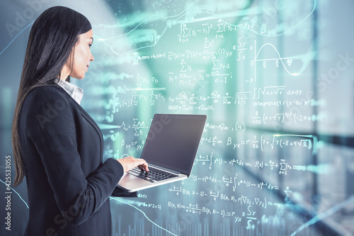 Online education concept with businesswoman with laptop in front of virtual wall with mathematical formulas