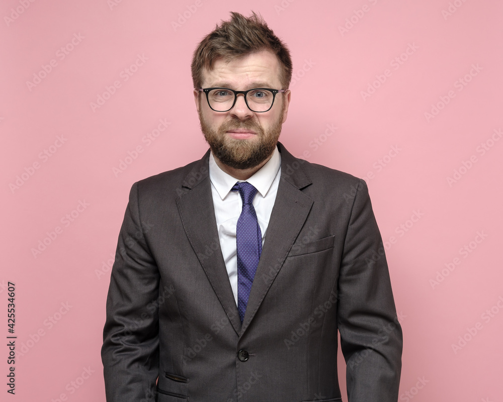 Disheveled, tired man in a business suit in stress, he was not able to conclude a bargain and very upset. Pink background. Disheveled, tired man in a business suit in stress, he was not able to conclude a bargain and very upset. Pink background.