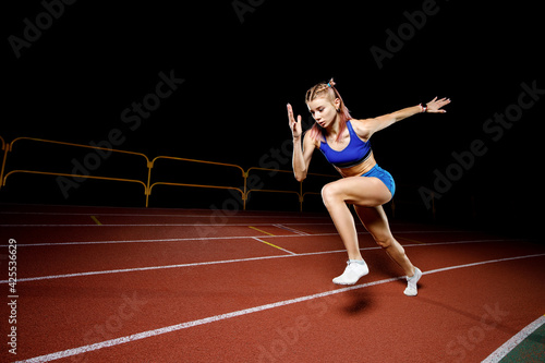 Female track runner bursting off starting block © skumer