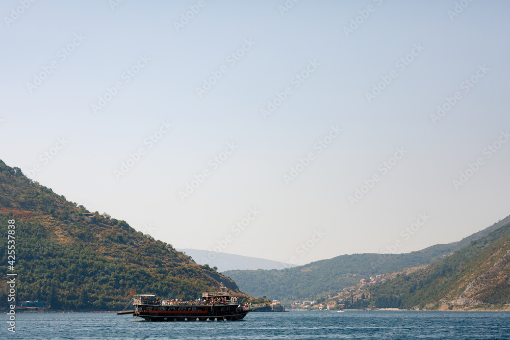 Double-deck ship with passengers on board. Boat trip on the Bay of Kotor.