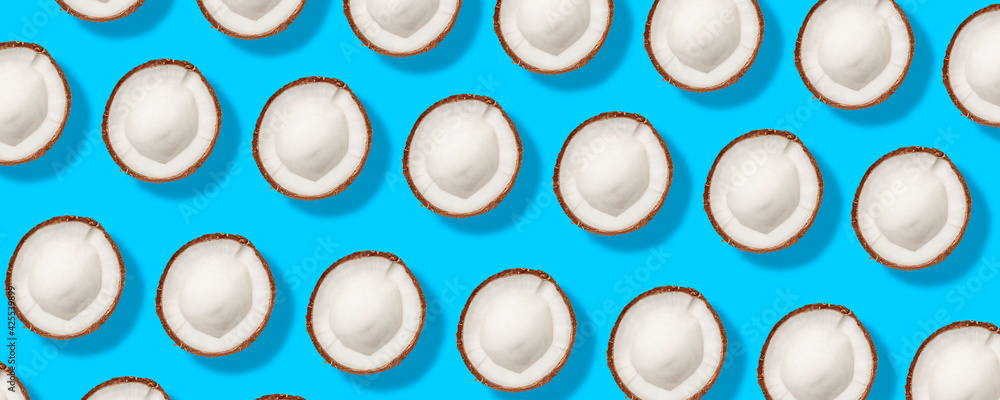 Pattern with ripe coconuts on blue background. Banner. Flat lay, top view Pattern with ripe coconuts on blue background. Banner. Flat lay, top view