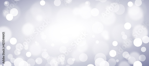Abstract white bokeh on blue background, sparkles and shimmering background in the shape of a circle. Defocused lights on a blue background.