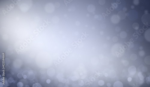 Abstract white bokeh on blue background, sparkles and shimmering background in the shape of a circle. Defocused lights on a blue background.