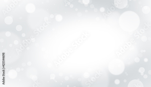 Defocused white lights on a gray background. Abstract bokeh on a white background.