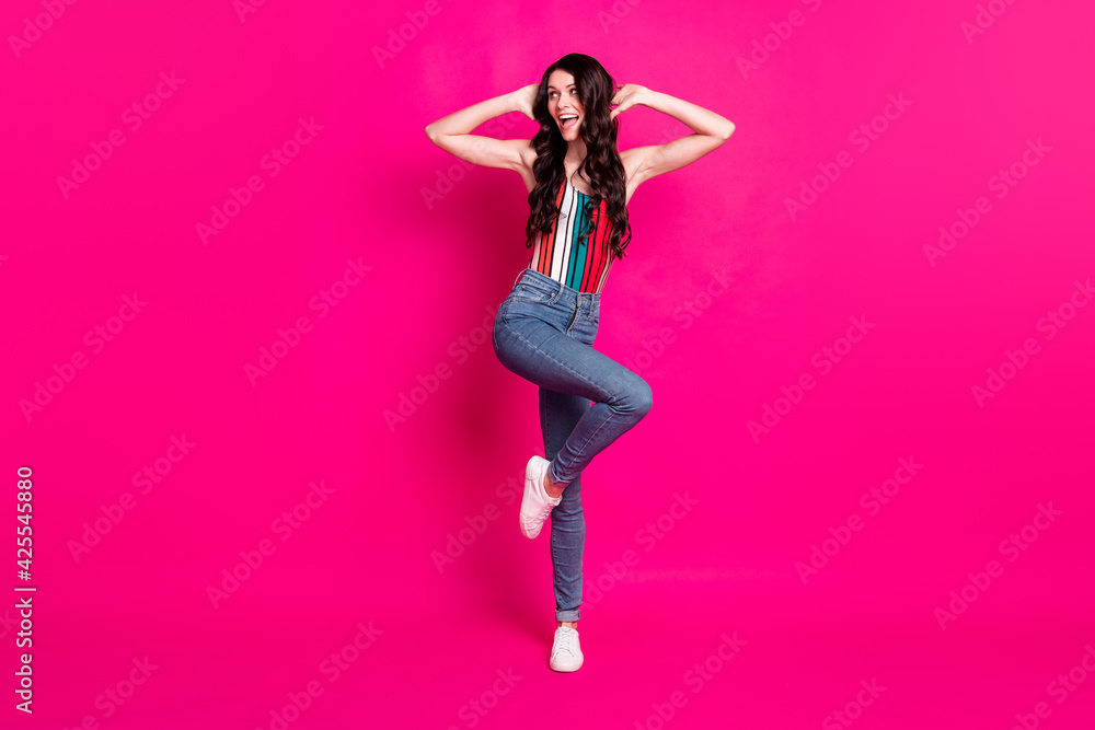 Full size photo of optimistic cute brunette lady dance wear top jeans sneakers look empty space isolated on vivid pink background Full size photo of optimistic cute brunette lady dance wear top jeans sneakers look empty space isolated on vivid pink background
