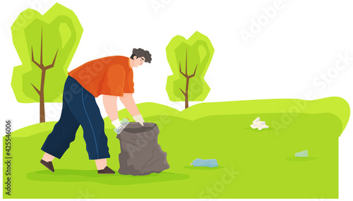 Man is removing plastic and paper waste outdoors during cold season. Guy throws bottle in trash bag