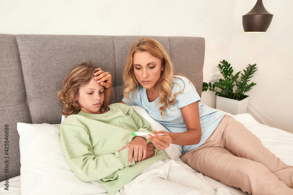 A picture of a mother checking her sons temperature A picture of a mother checking her sons temperature