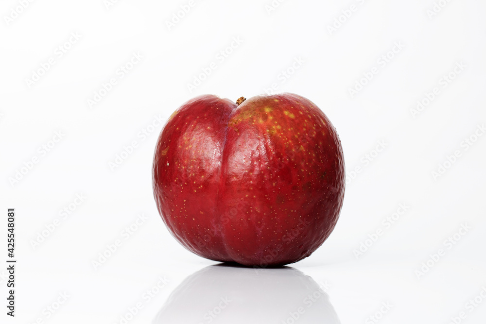 Ripe plum isolated on white background with shadow and reflection. Overripe old ugly plum. Spoiled food Ripe plum isolated on white background with shadow and reflection. Overripe old ugly plum. Spoiled food