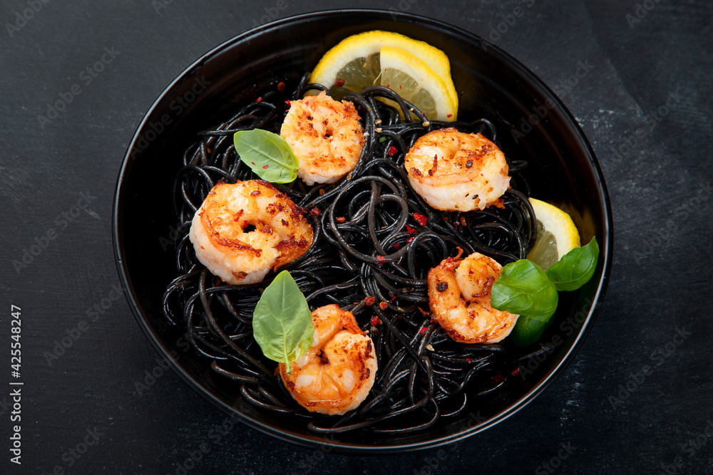 Spaghetti with shrimps and parmesan on dark background. Tasty appetizings seafood pasta. Spaghetti with shrimps and parmesan on dark background. Tasty appetizings seafood pasta.